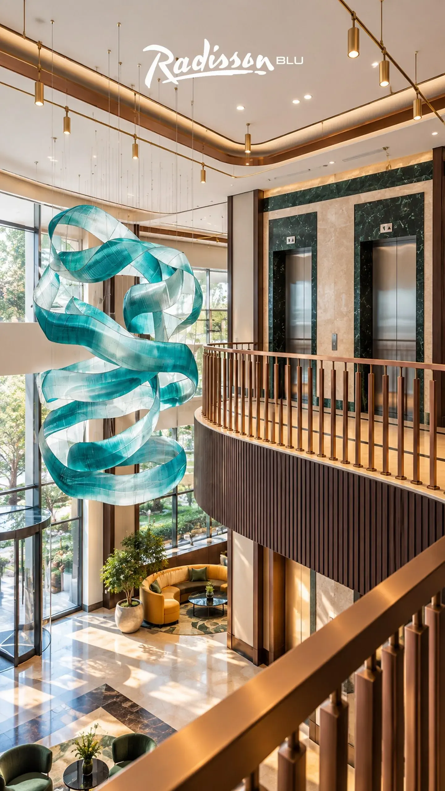 Hotel atrium with a turquoise glass ribbon sculpture and bronze balcony railing