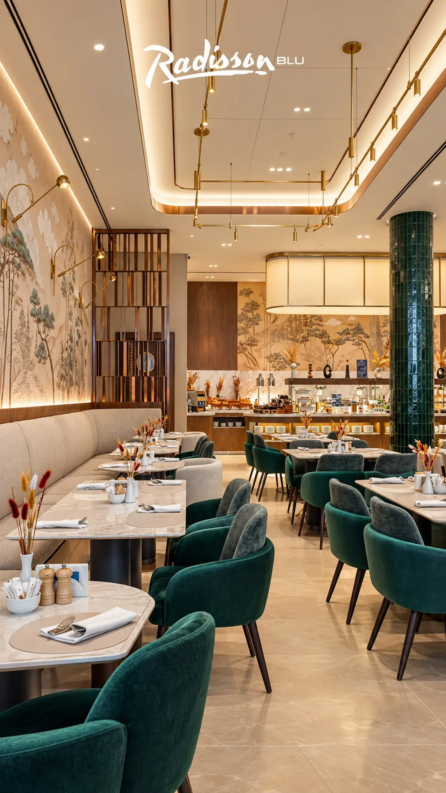 Hotel restaurant with green velvet chairs, marble tables and a painted landscape mural