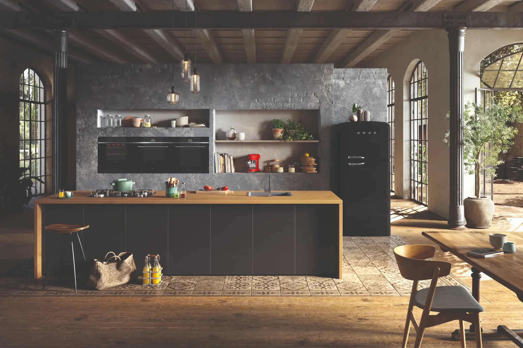 Dark industrial kitchen with a black Smeg retro fridge, built-in ovens and a wooden island